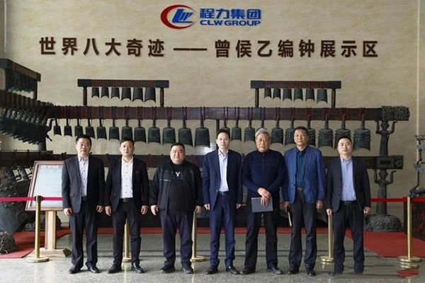 在程力汽車集團總部迎賓大廳，雙方代表觀摩世界八大奇跡編鐘后合影紀(jì)念